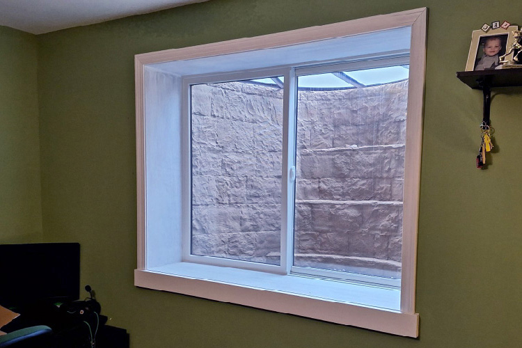 Rockwell well with Andersen gliding egress window view from the outside looking into well.