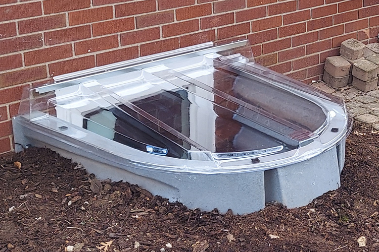 Exterior view of a gray Wellcraft 2062 egress well at a home in White Lake, Michigan.